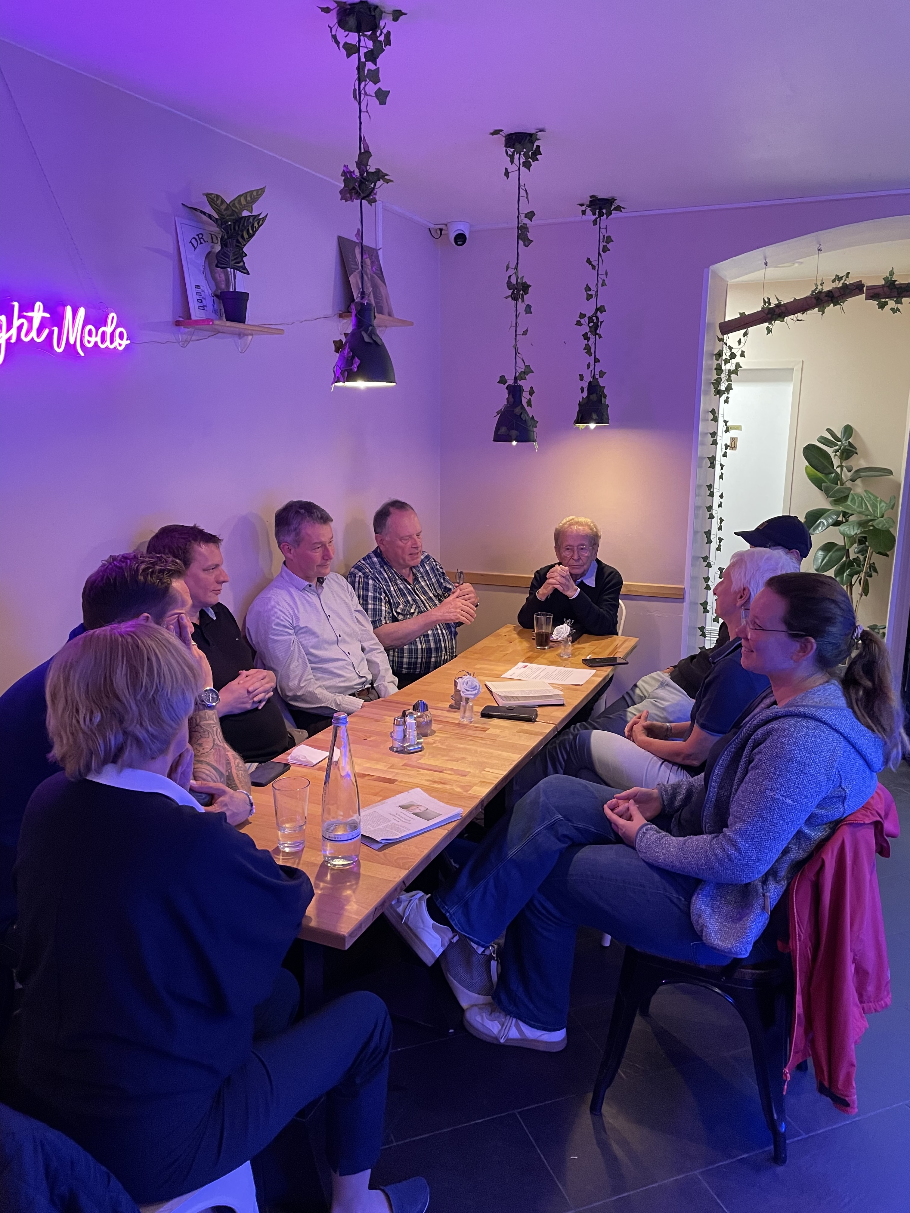 Mehrere Personen sitzen an einem Tisch.